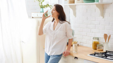 Gorgeous Woman Drinking Water In Her Kitchen